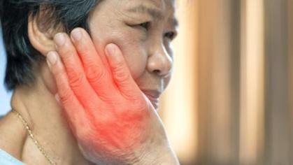 Women holding cheek with pain